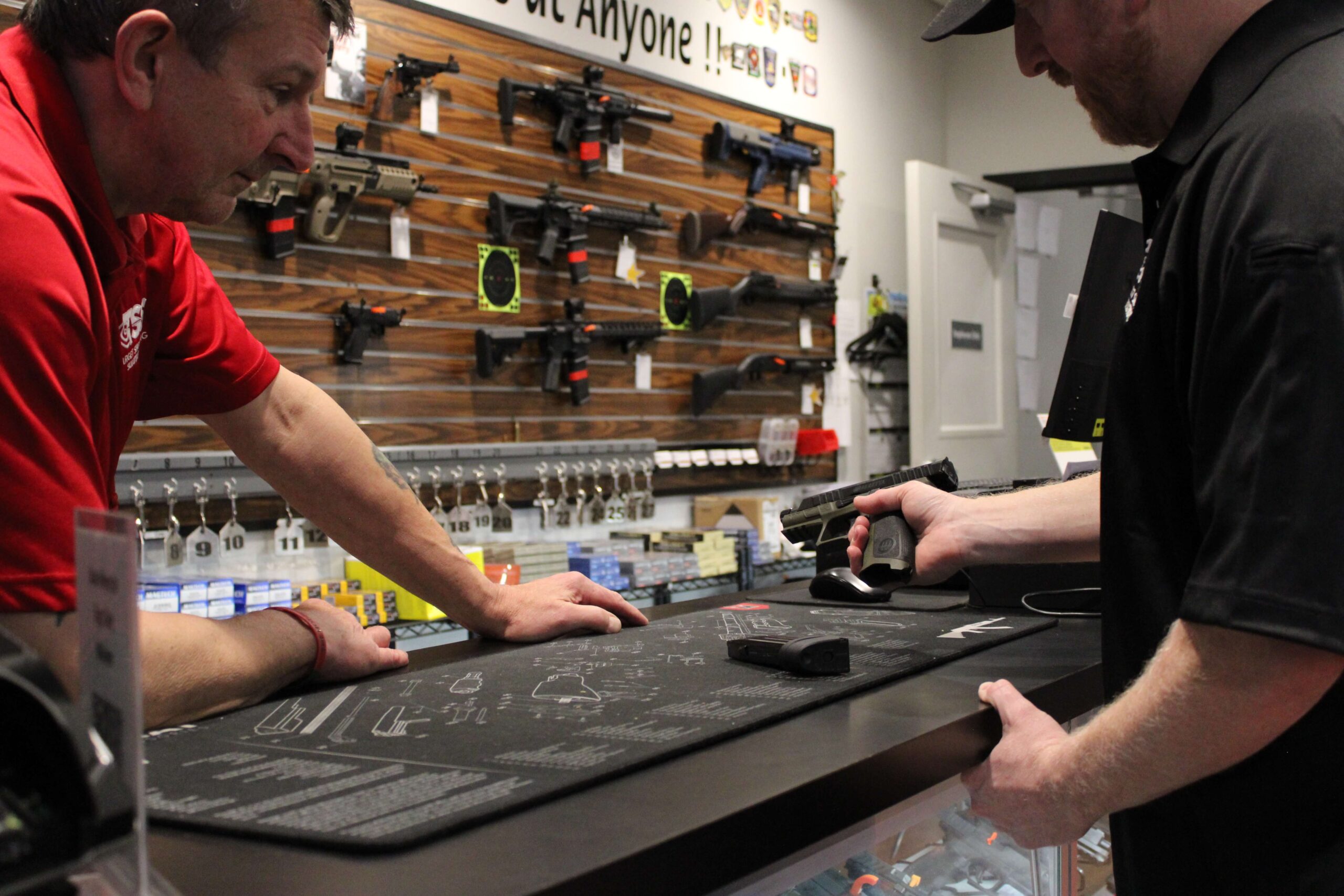 TSS staff helping a customer at the gun counter